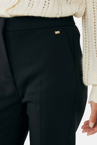 Pantalon chino 7/8 noir de Mexx, avec une petite plaque dorée sur la ceinture et un tombé impeccable.