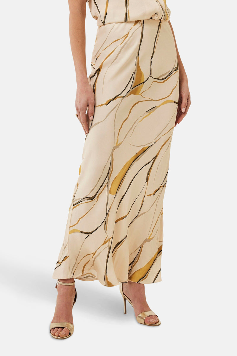 Mexx lange veelkleurige rok met abstract golvend patroon en gouden hakken.