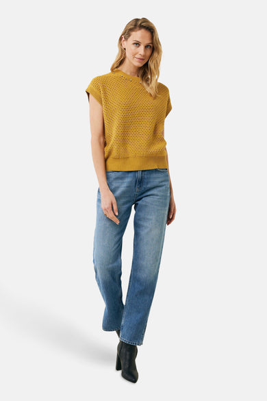 Pull à col rond jaune de MEXX, en maille texturée, porté avec un jean bleu et des bottines noires.