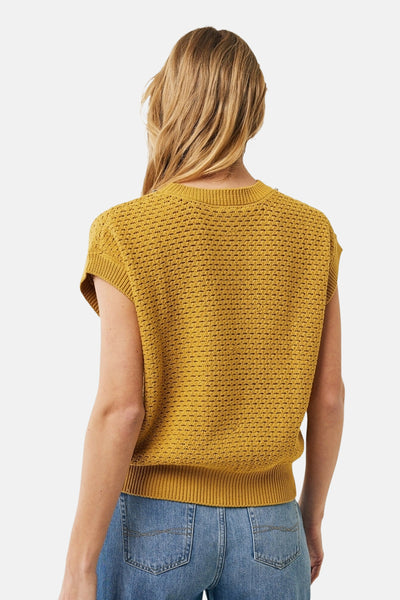 Pull à col rond jaune de MEXX, en maille ajourée, porté avec un jean taille haute, vue de dos.
