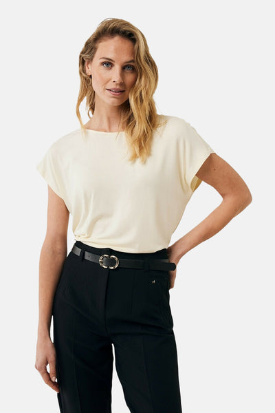 T-shirt à manches courtes écru de MEXX, porté avec un pantalon taille haute et une ceinture noire.
