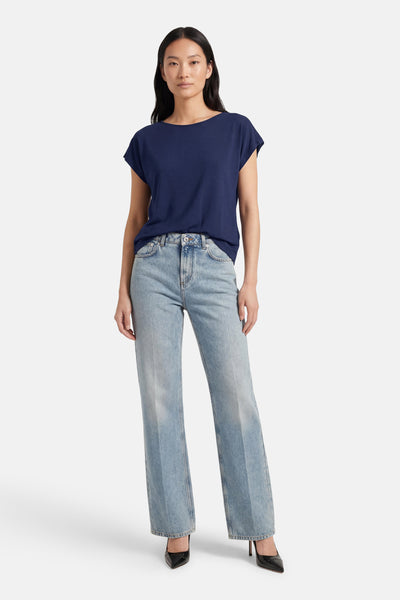 T-shirt bleu uni de MEXX, porté avec un jean délavé et des escarpins noirs.
