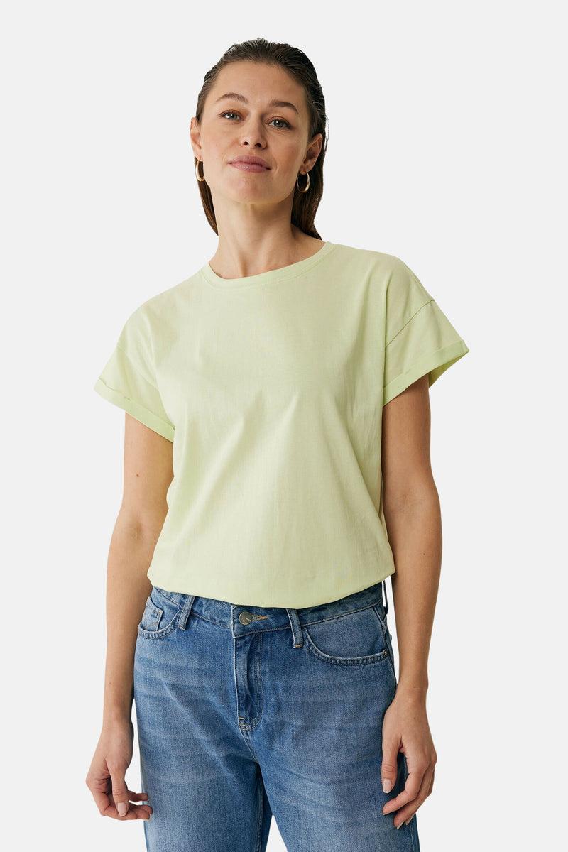T-shirt vert à manches courtes de MEXX, porté avec un jean bleu.
