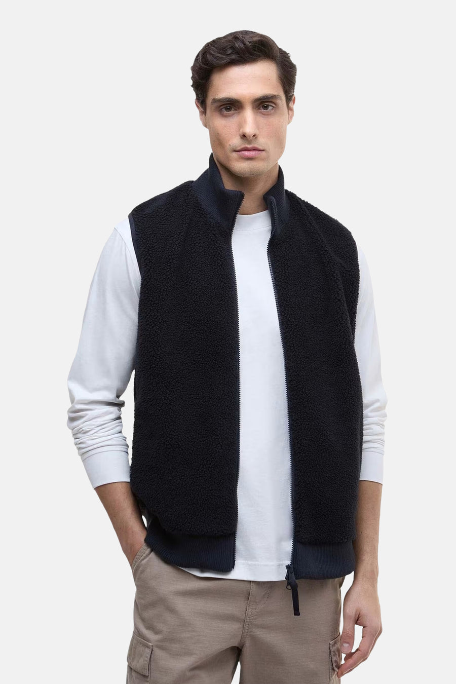 Marineblauwe fleece bodywarmer van Barbour, gedragen over een wit overhemd met lange mouwen.