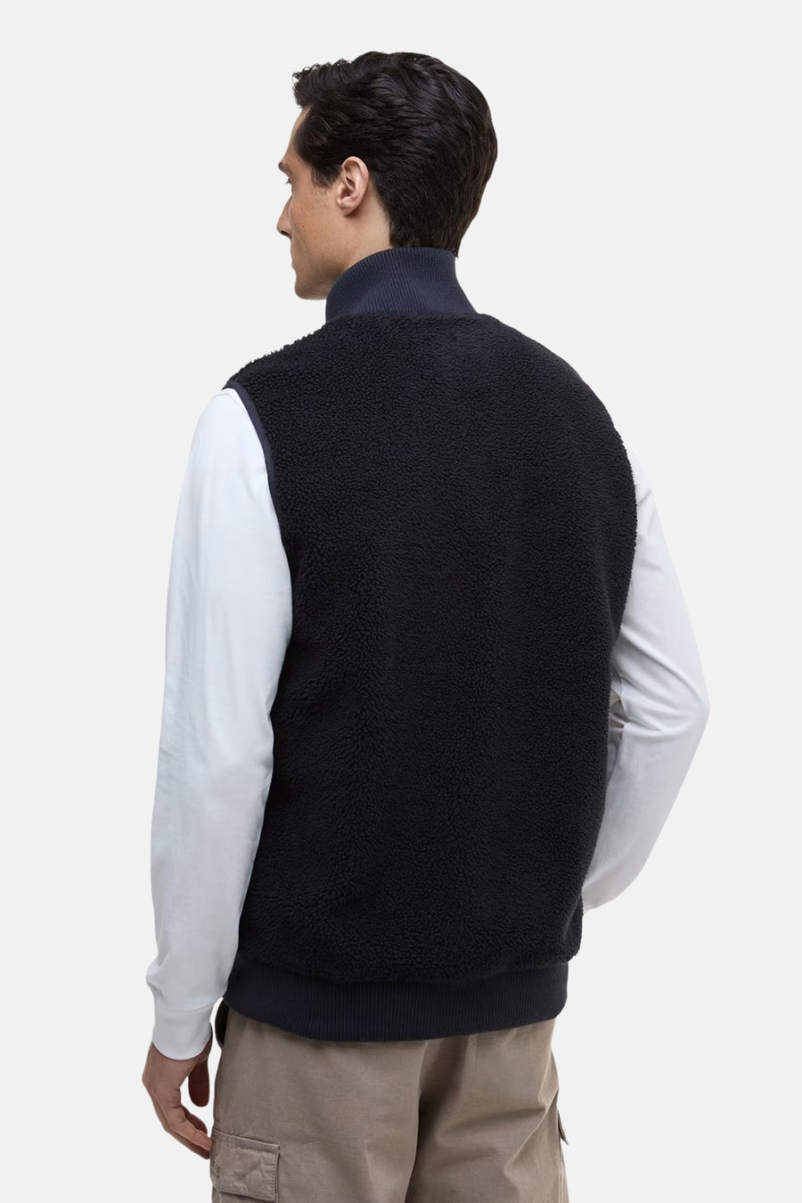 Veste sans manches en polaire bleu marine de Barbour, portée sur une chemise blanche à manches longues.
