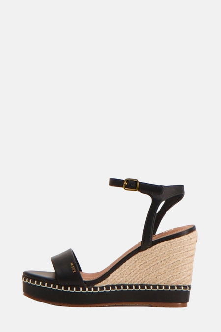 Escarpin compensé noir de MEXX avec semelle plateforme ornée de surpiqûres blanches, vue latérale.
