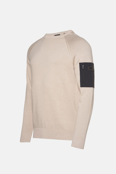 Beige ronde hals trui van Barbour, met een zwarte zak met rits op de mouw.
