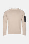 Barbour ronde hals trui beige met zwarte ritszak op de mouw.