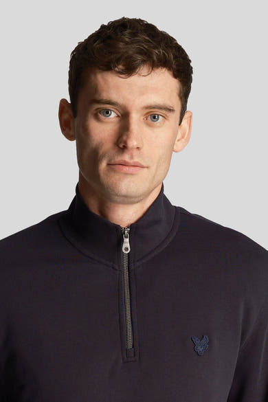 Blauwe sweater met opstaande kraag van LYLE & SCOTT met ritssluiting en geborduurd logo op de borst.