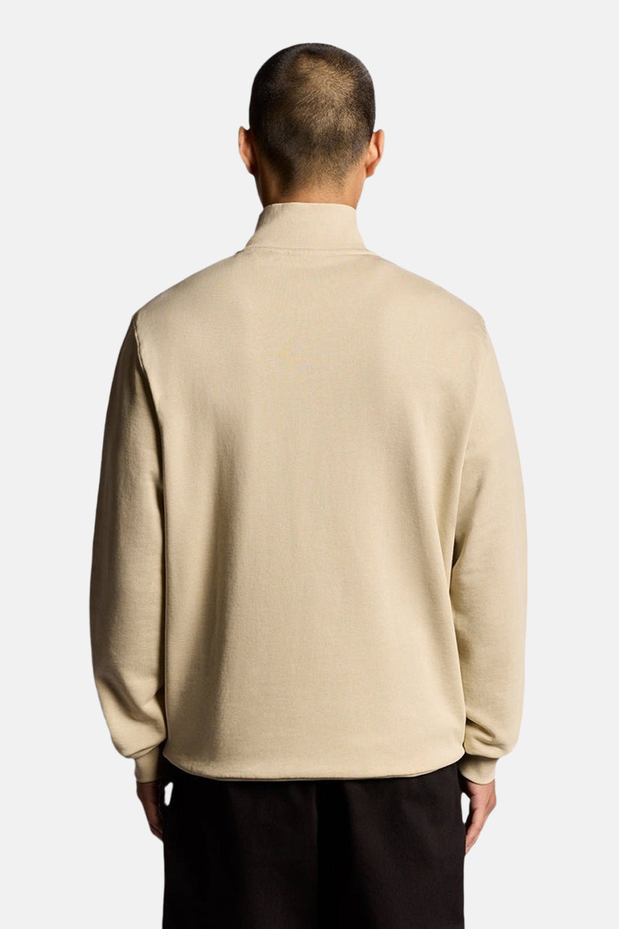 Beige sweater van LYLE & SCOTT, achterkant, gedragen met een zwarte broek.