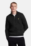 Zwarte sweater van LYLE & SCOTT, achterkant, gedragen met een wit T-shirt en een zwarte joggingbroek.