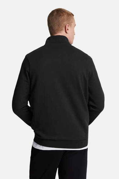 Sweat noir de LYLE & SCOTT, vue arrière, porté avec un t-shirt blanc et un pantalon de survêtement noir.