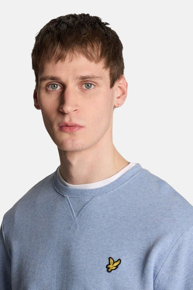 Sweat bleu de LYLE & SCOTT, col rond, avec un petit logo jaune brodé.

