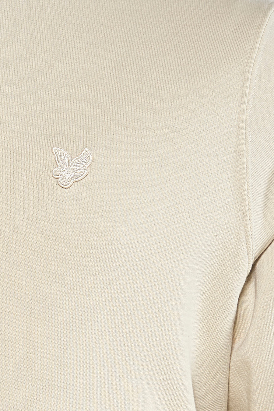 Sweat-shirt écru de LYLE & SCOTT, avec un logo brodé discret sur la poitrine, texture maille fine.