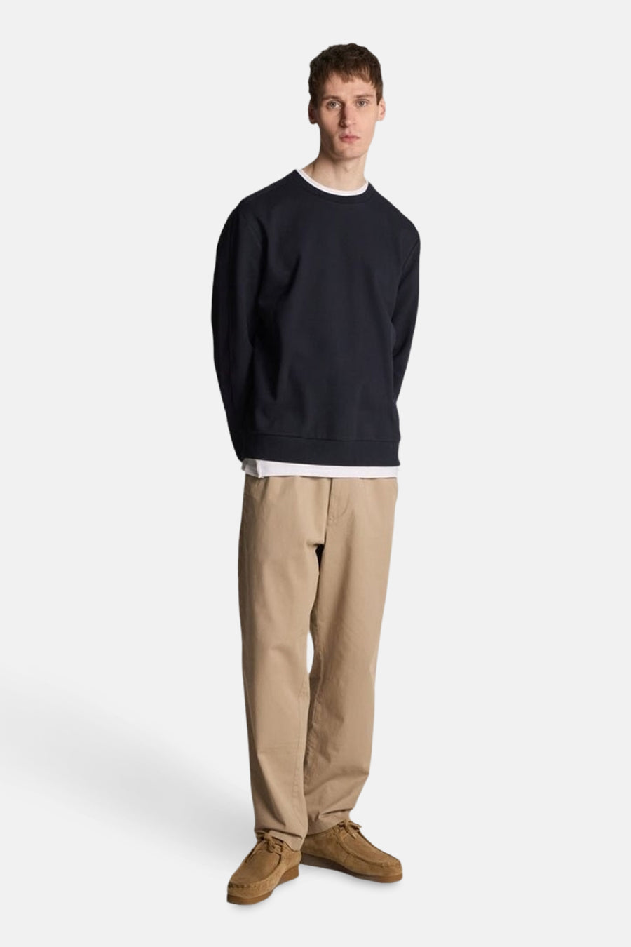 Sweat bleu de LYLE & SCOTT, porté avec un t-shirt blanc et un pantalon chino beige.