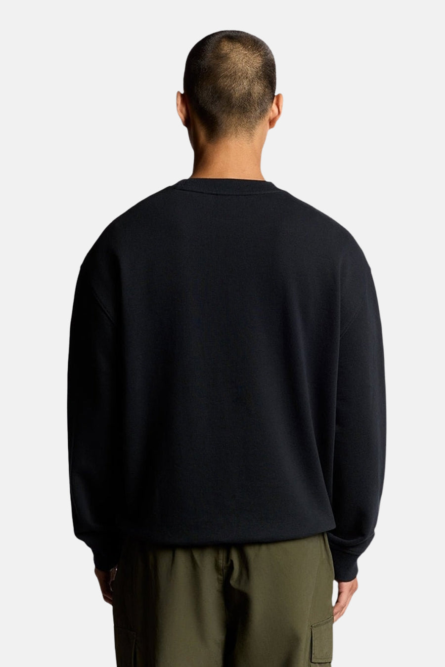 Donkerblauwe sweater van LYLE & SCOTT, van achteren gezien, gedragen met een olijfgroene cargobroek.