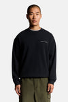 Donkerblauwe trui met ronde hals van LYLE & SCOTT, gedragen met een kaki broek.