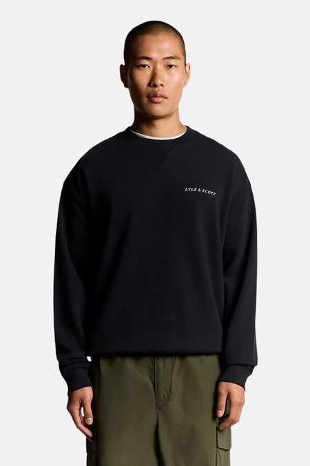 Donkerblauwe trui met ronde hals van LYLE & SCOTT, gedragen met een kaki broek.