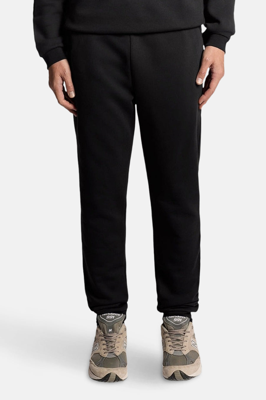 Zwarte joggingbroek van LYLE & SCOTT, effen textiel met een hand op het dijbeen.