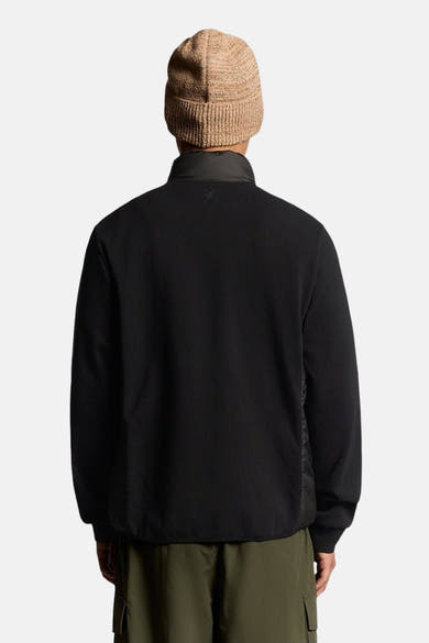 Veste de pluie noire par LYLE & SCOTT, vue de dos avec un bonnet beige.