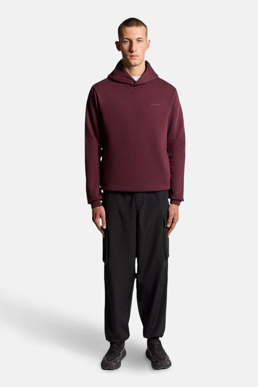 Bordeaux hoodie van LYLE & SCOTT, gedragen met een zwarte wijde cargobroek en sneakers.