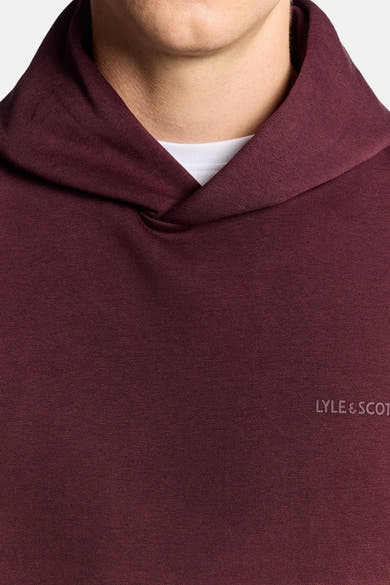 Sweat à capuche bordeaux de Lyle & Scott, avec un col châle et un t-shirt blanc visible.