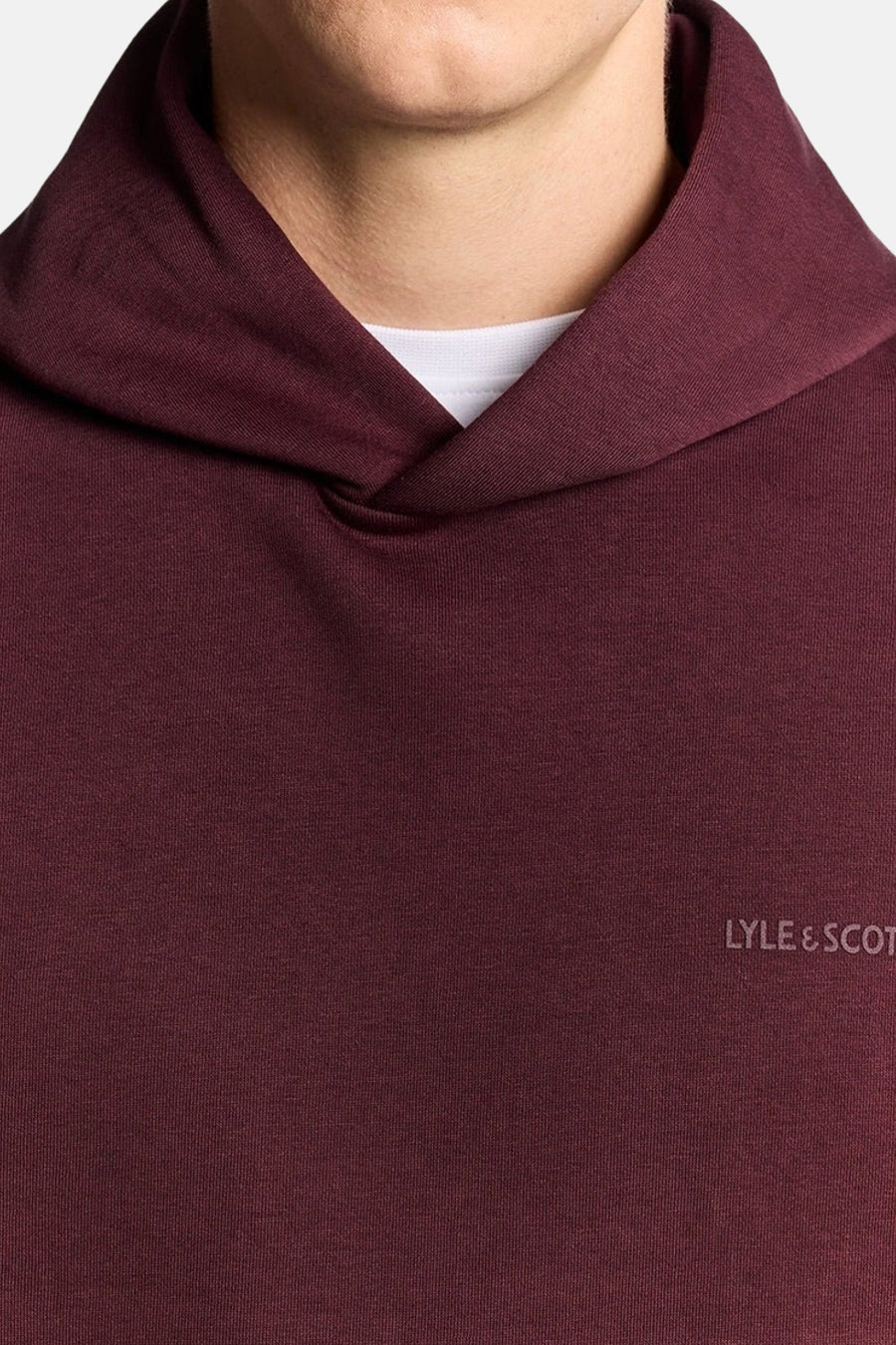 Sweat à capuche bordeaux de Lyle & Scott, avec un col châle et un t-shirt blanc visible.
