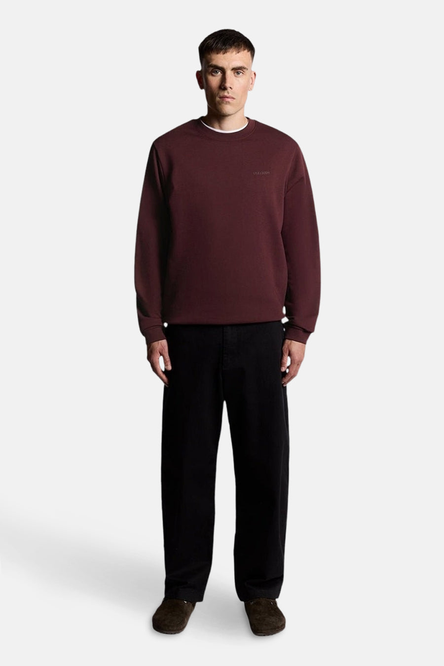 Bordeaux sweatshirt van LYLE & SCOTT, gedragen met een zwarte broek en bruine schoenen.