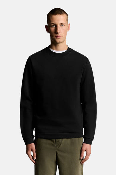 Zwarte rondehals sweatshirt van LYLE & SCOTT, gedragen over een wit T-shirt, in een getextureerde stof.