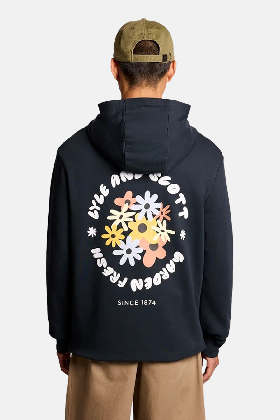 Blauwe hoodie van LYLE & SCOTT met bloemenprint en tekst op de borst, gedragen met een beige broek en een kaki pet.