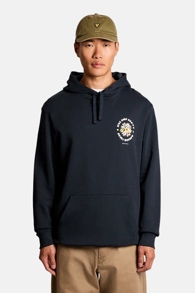 Blauwe hoodie van LYLE & SCOTT met meerkleurig bloemenpatroon op de borst, gedragen door een man in een beige broek en kaki pet.