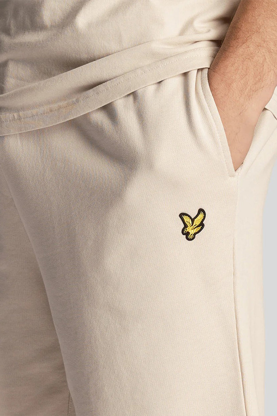 Korte beige short van LYLE & SCOTT, met een hand in de zak, met geborduurd logo.