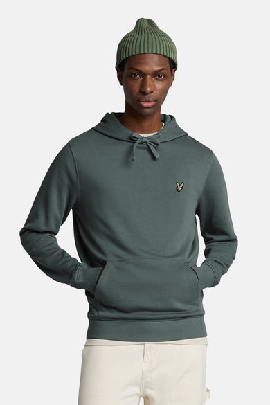 Kaki hoodie van LYLE & SCOTT, met capuchon, gedragen met een muts en een beige broek.