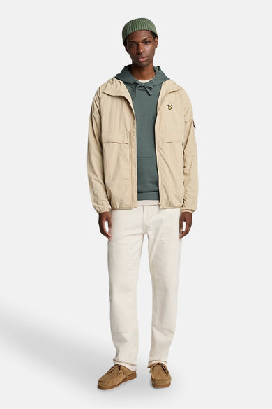 Kaki hoodie van Lyle & Scott, gedragen met een beige jas en een groene muts.