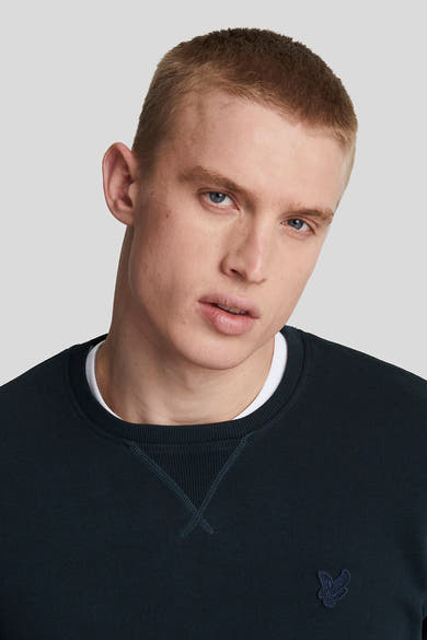 Marineblauwe sweater van LYLE & SCOTT, met ronde hals en subtiel geborduurd logo-motief op de borst.