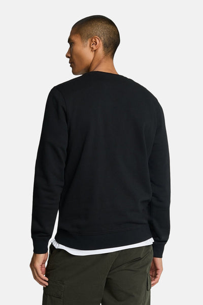 Sweat-shirt noir de LYLE & SCOTT, avec ourlet à bords-côtes et coupe classique, porté avec un pantalon cargo.