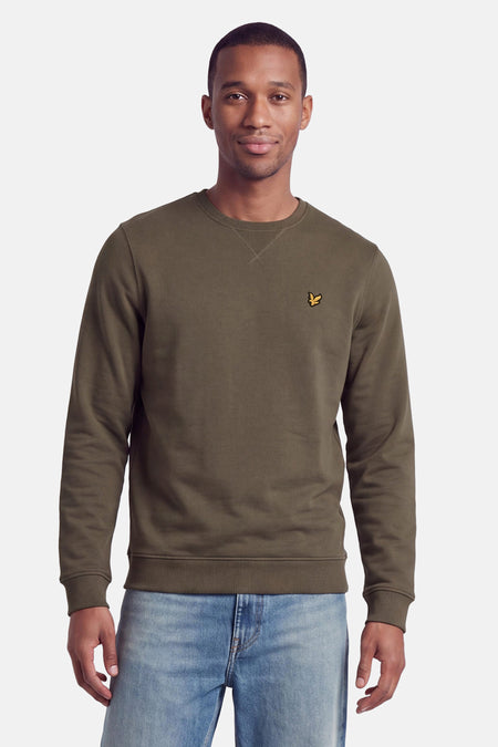 Sweat col O kaki de LYLE & SCOTT, coupe classique, broderie oiseau doré sur poitrine, porté avec jeans délavés, vue frontale.