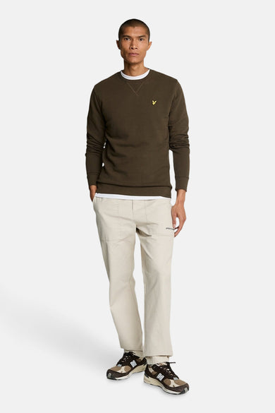 Sweat-shirt kaki de LYLE & SCOTT, porté avec un t-shirt blanc et un pantalon beige.