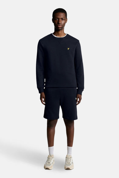 Sweat-shirt bleu marine encolure ras du cou de Lyle & Scott, porté avec un short assorti et des baskets.