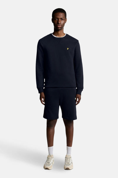 Sweat-shirt bleu marine encolure ras du cou de Lyle & Scott, porté avec un short assorti et des baskets.