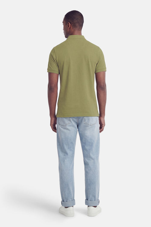 Polo vert à manches courtes de BARBOUR CLASSIC, vu de dos, avec un motif texturé, porté avec un jean clair et des baskets blanches.