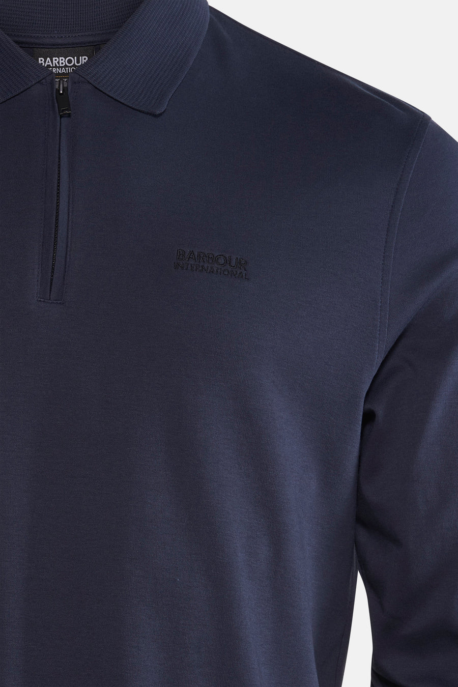 Blauwe polo met lange mouwen van Barbour, met een ritssluiting tot halverwege en een logo op de borst.