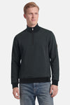Sweat col montant vert de BARBOUR avec fermeture éclair courte, col côtelé et patch sur la manche, porté avec un jean.