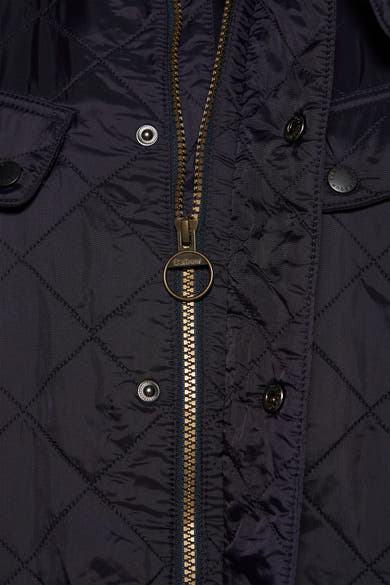 Donkerblauwe regenjas van Barbour met gouden ritssluiting en ruitpatroon.