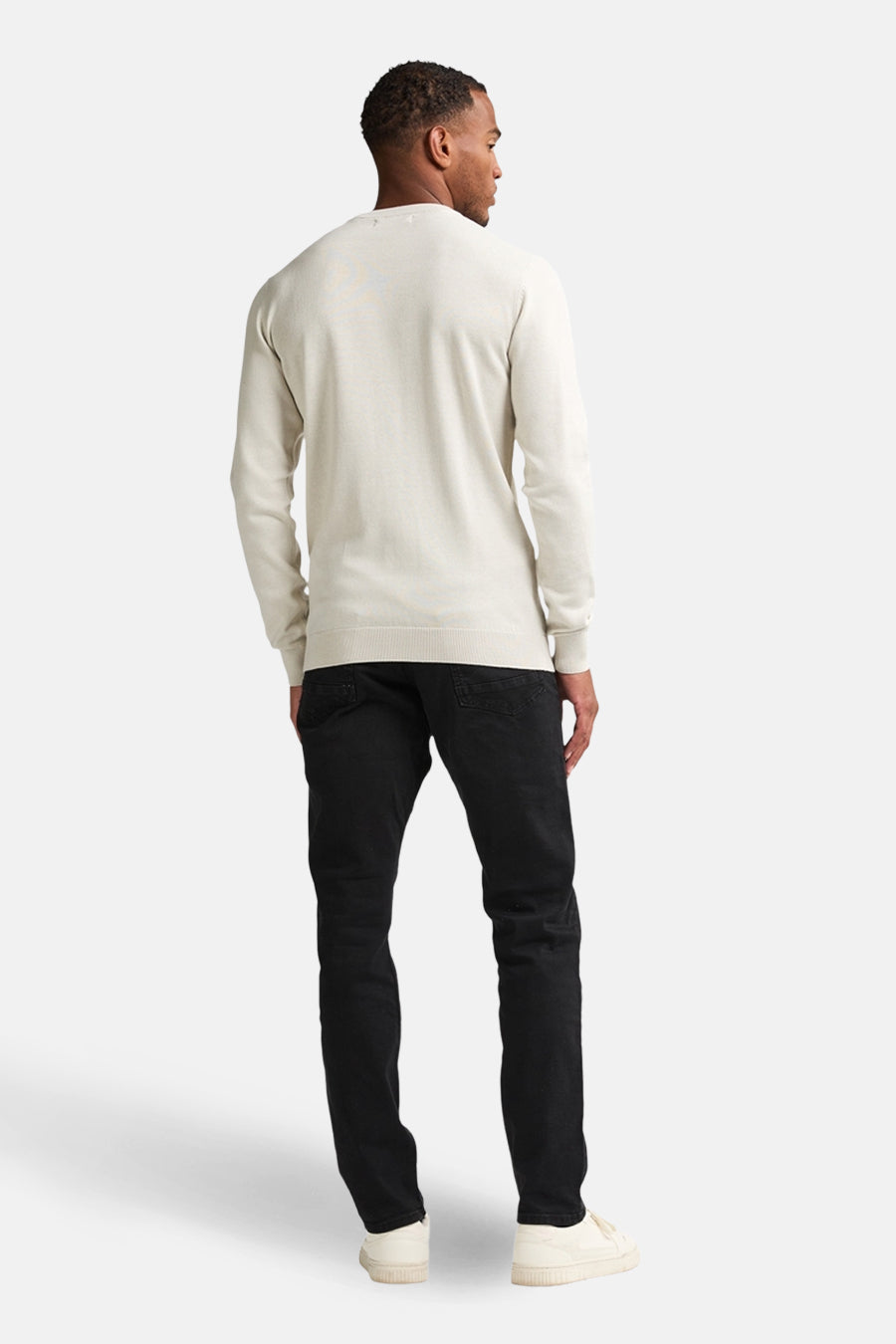 Pull à col rond écru de Petrol Industries, porté avec un pantalon noir et des baskets blanches, vue de dos.
