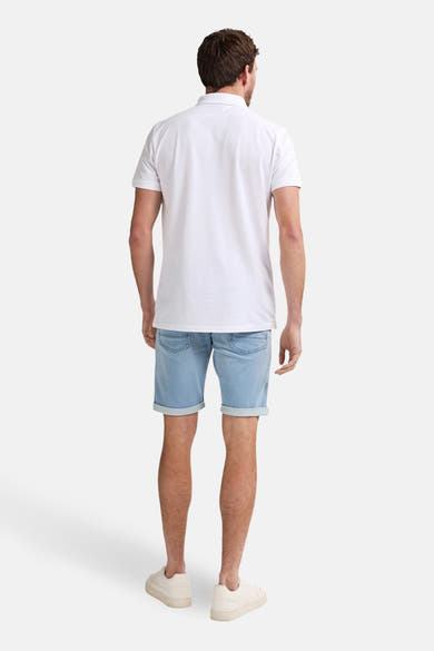 Short en denim bleu clair de Petrol Industries, porté avec un polo blanc et des chaussures beiges.