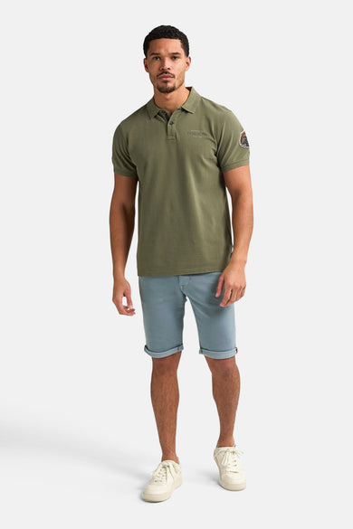 Korte blauwe short van Petrol Industries met rode zoom en olijfgroen T-shirt.
