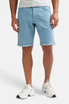 Short bleu de Petrol Industries® avec ourlets retroussés, porté avec un t-shirt à rayures et des baskets blanches.