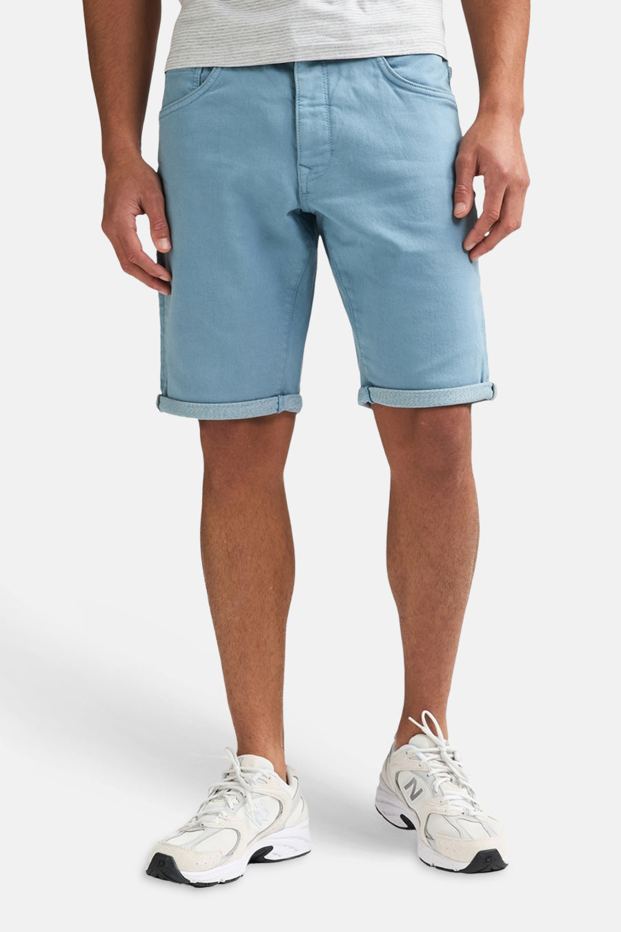 Short bleu de Petrol Industries® avec ourlets retroussés, porté avec un t-shirt à rayures et des baskets blanches.