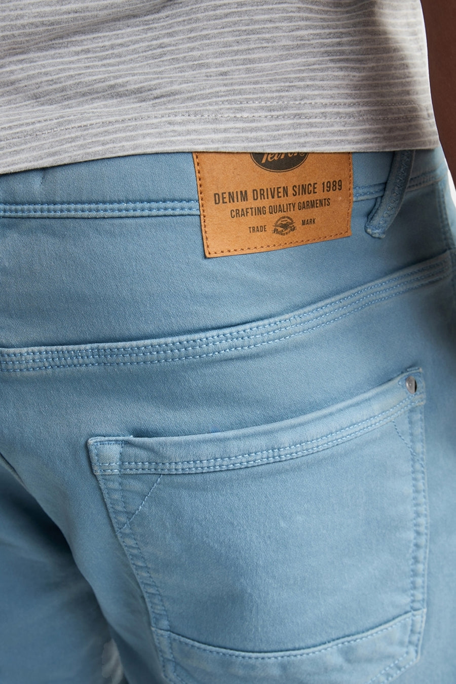 Short bleu en denim de Petrol Industries avec étiquette en cuir marron et poche arrière.
